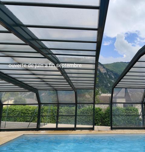 ein Schwimmbad mit Blick auf einen Berg in der Unterkunft Ossau T2 5 personnes piscine climatisation 1 chambre draps serviettes inclus parking moustiquaires lave vaisselle lave linge tout confort in Bielle