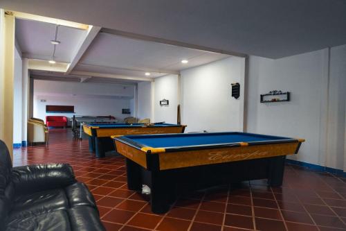 two pool tables in a room with couches at Hotel Sinai SV in Macanal