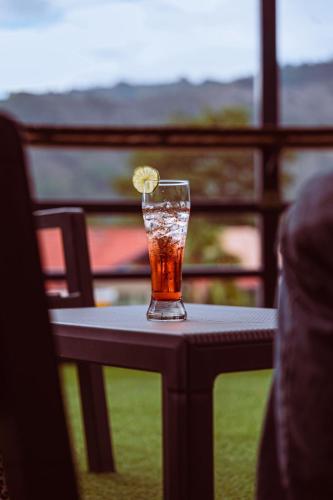 a drink on a table with a lemon on it at Hotel Sinai SV in Macanal