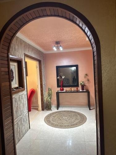 un arco que conduce a una habitación con una mesa en Appartement Vue Mer avec Jacuzzi Tout équipé proche centre-ville Bienvenue à Bizerte dans un appartement haut standing avec une vue imprenable sur la mer Situé à seulement 5 minutes du centre-ville, en Bizerte