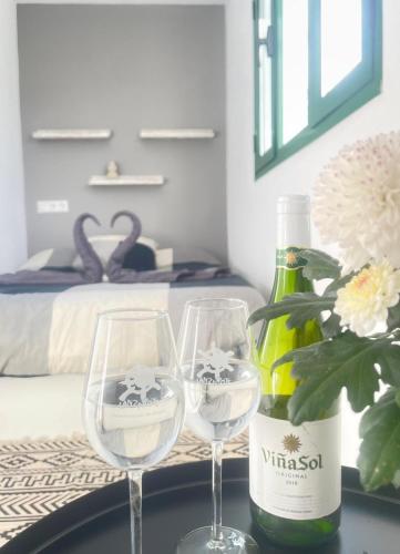 zwei Weingläser auf einem Tisch mit einer Flasche Wein in der Unterkunft El Rinconcito de Luisa in Teseguite