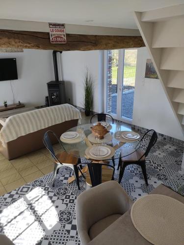 a living room with a table and chairs at les pti'colos in La Neuville-lès-Dorengt