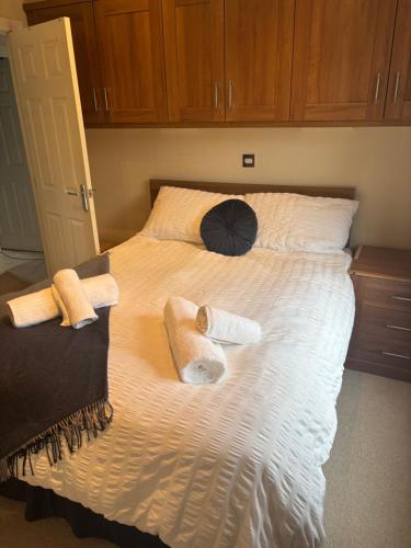 a bed with towels and an umbrella on it at Gressingham 9 - South Lakes Leisure Village - lodge on the lake in Carnforth