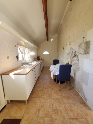 - une cuisine avec un évier et une table dans une chambre dans l'établissement Les Gîtes du Cormier, à Sambin