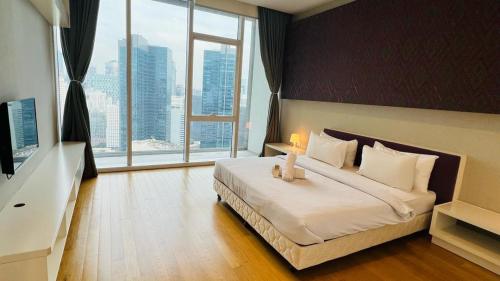 a bedroom with a large bed with a large window at The Suites At Platinum KLCC in Kuala Lumpur
