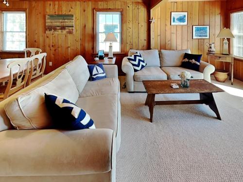 a living room with two couches and a table at A Charm of Finches in Surf City