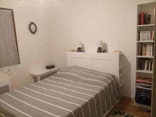 a bedroom with a bed and a book shelf at T3 RDC 2/4 pers, terrasse et garage privé. in Gap