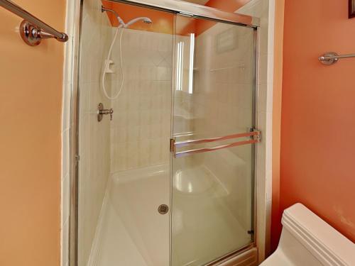 a shower with a glass door in a bathroom at A Charm of Finches in Surf City