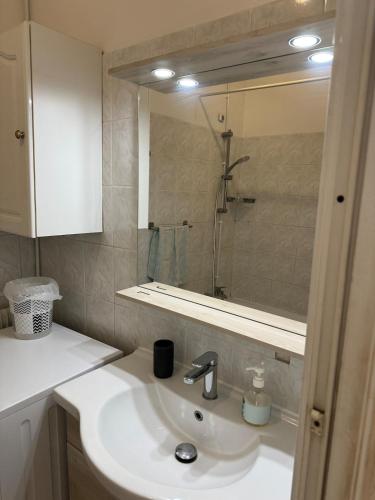 une salle de bain avec un lavabo et un miroir dans l'établissement juan les pins centre proche mer 3 pièces, à Juan-les-Pins