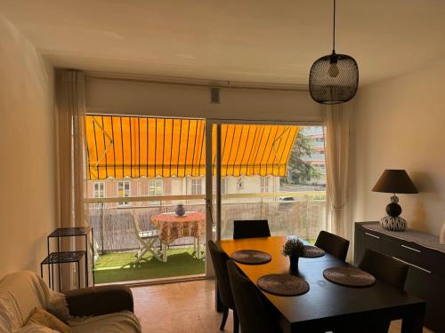 un salon avec une table et une grande fenêtre dans l'établissement juan les pins centre proche mer 3 pièces, à Juan-les-Pins