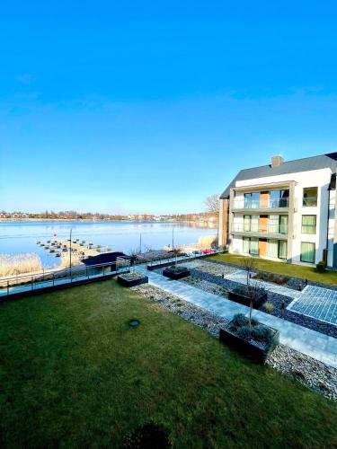 an aerial view of a building and a body of water at Apartament ŻURAW z widokiem na jezioro Drwęckie ROYAL APARTS OSTRÓDA in Ostróda