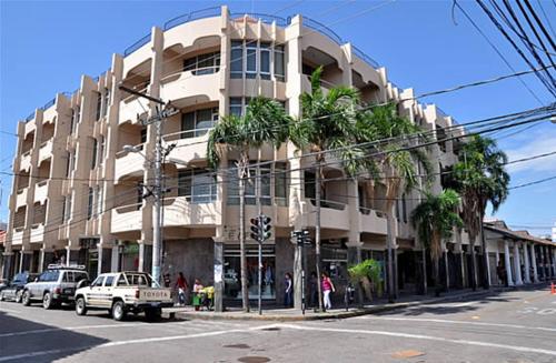 a large building on a street with cars parked in front at Hotel Libertador in Santa Cruz de la Sierra