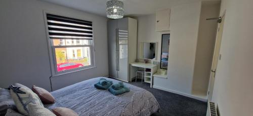 a bedroom with a bed with two blue pillows on it at Unique Exmouth Family Holiday Home Close to Beach & Town in Exmouth