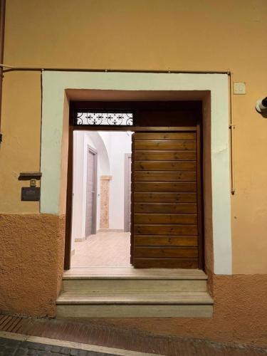 a wooden door in a building with stairs at FRALINA House in Monterotondo