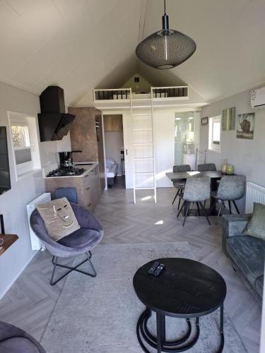 a living room with a couch and a table at Tiny House 303 in Lathum