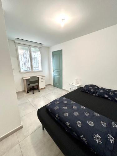 una camera da letto con un letto e una scrivania di Joli RDC à 2 pas du centre ville ad Avignone