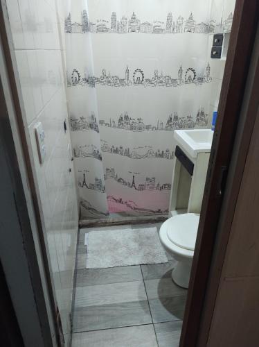 a bathroom with a toilet and a shower curtain at Casa Luna in Parana