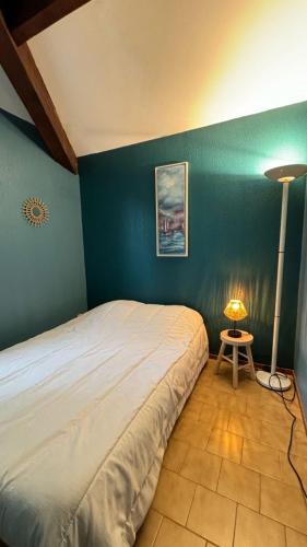 une chambre avec un grand lit et une lampe dans l'établissement Appartement à Bandol, à Bandol