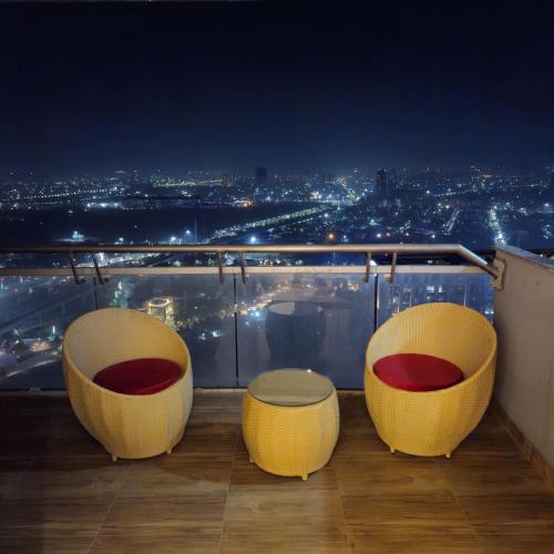a balcony with three chairs and a view of the city at Vogue studio by Shivangi in Noida