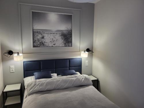 sypialnia z dużym łóżkiem z niebieskim zagłówkiem w obiekcie Apartament przy plaży w mieście Niechorze