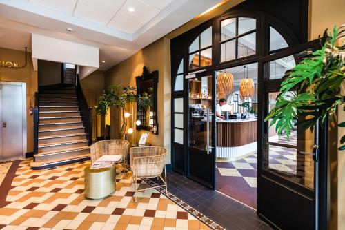 a lobby of a hotel with a staircase and a store at Hotel De Diane in Sables-dʼOr-les-Pins