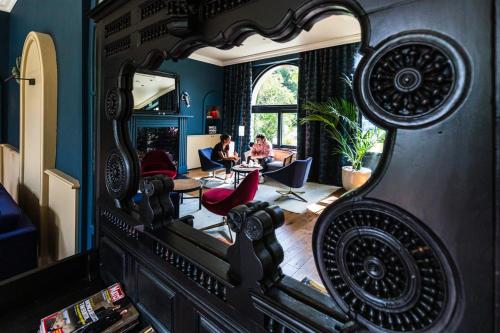 a mirror in a living room with a woman in a living room at Hotel De Diane in Sables-dʼOr-les-Pins
