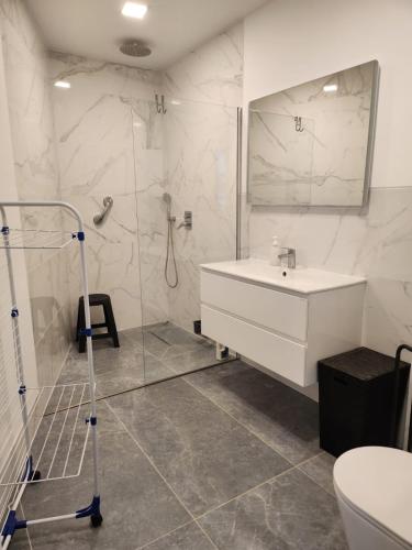 a white bathroom with a sink and a shower at Santa Beatriz Apartment in Machico