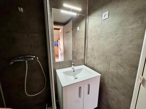 une salle de bain avec un lavabo blanc et une douche dans l'établissement Maison Piscine Clim à 2 pas de la Mer, à Saint-Vincent-sur-Jard