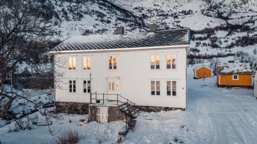 a white house in the snow on a snowy mountain at Fiskeværet Nesland in Kvalvik