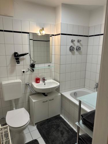 a bathroom with a toilet and a sink and a tub at Linda Ninh Apartment 6 Altstadt in Dresden