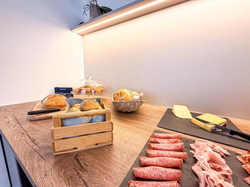 a table with meat and pastries and bread on it at Strengen Guesthouse in Caldaro