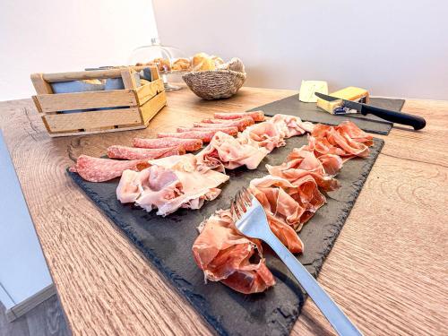 a bunch of cuts of meat on a cutting board at Strengen Guesthouse in Caldaro