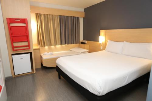 a hotel room with a large bed and a desk at ibis Copacabana Posto 5 in Rio de Janeiro