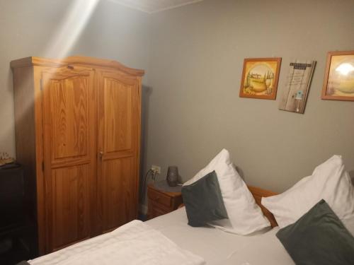 a bedroom with a bed and a wooden cabinet at Altstadt Oase Bernkastel-kues in Bernkastel-Kues