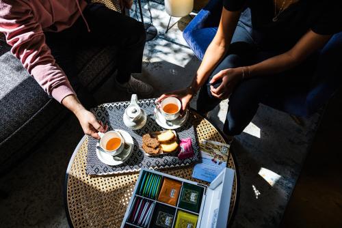 a group of people sitting around a table with cups of tea at Hotel De Diane in Sables-dʼOr-les-Pins