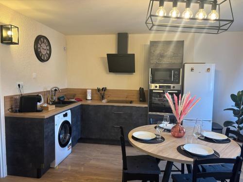 Il comprend une cuisine équipée d'une table et d'un réfrigérateur. dans l'établissement Gîte le Pfeffel à Colmar, à Colmar