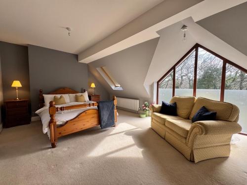 a bedroom with a bed and a couch in a room at Little Luckford in Wareham