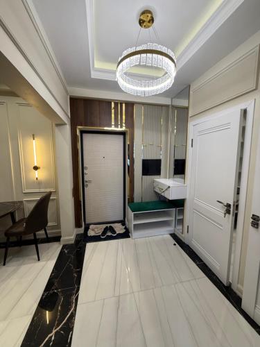 a hallway with a door and a desk and a chandelier at Айни60 in Dushanbe