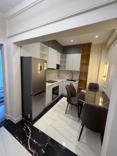 a kitchen with a black refrigerator and a table at Айни60 in Dushanbe
