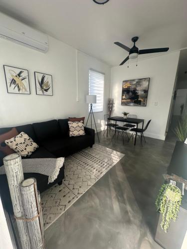 a living room with a black couch and a table at El Amanecer del Este 2 in Fajardo