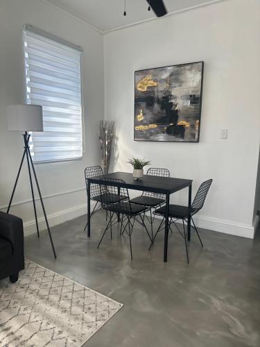 a dining room with a black table and chairs at El Amanecer del Este 2 in Fajardo
