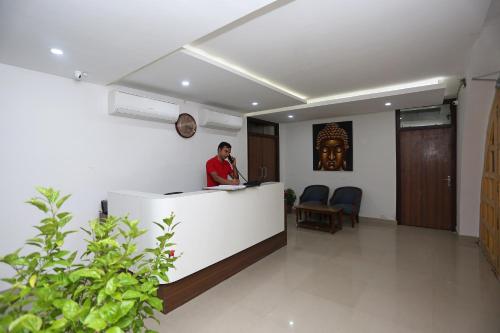 a man standing at a reception desk in a room at Super Hotel O Tulip Inn in Gorakhpur