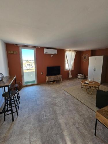 un salon avec un canapé et une télévision dans l'établissement Studio cosy au cœur de l'île, à Martigues