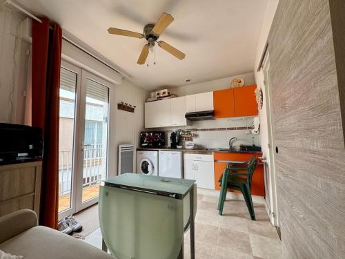 une cuisine avec un ventilateur de plafond et une table dans l'établissement T2 Cosy dans le Centre Parking, à Saint-Vincent-sur-Jard