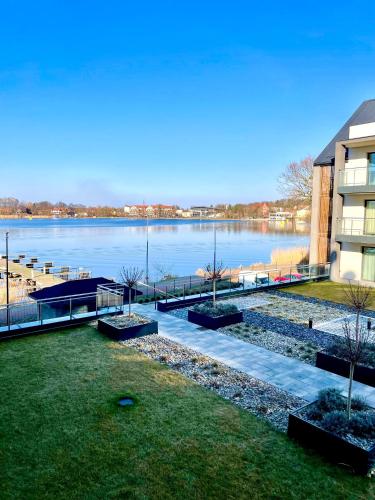 a view of a large body of water next to a building at Apartament ŻURAW z widokiem na jezioro Drwęckie ROYAL APARTS OSTRÓDA in Ostróda