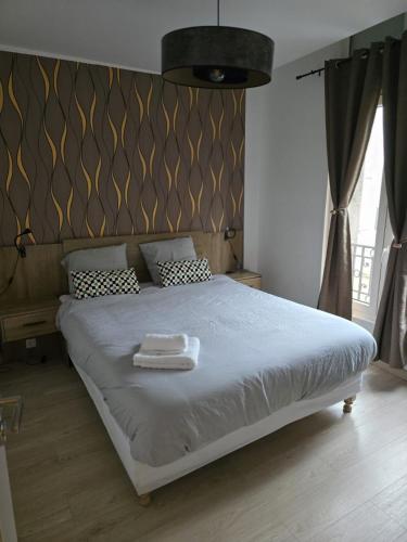 une chambre avec un lit avec deux serviettes blanches dessus dans l'établissement Hamdan Suite, à Reims