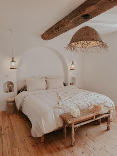 une chambre avec un grand lit et une table dans l'établissement Charmante maison en pierres, séjour à la ferme, à Saint-Georges-dʼEspéranche
