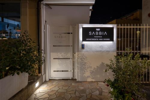 a white door with a sign on it at Sabbia Tropea Apartments and Rooms in Tropea