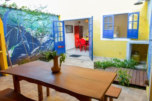 a room with a table and a house with blue doors at Casa Portal do Pati in Lençóis