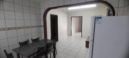 a room with a table and chairs and a refrigerator at Casa Ponte Serrada in Joinville